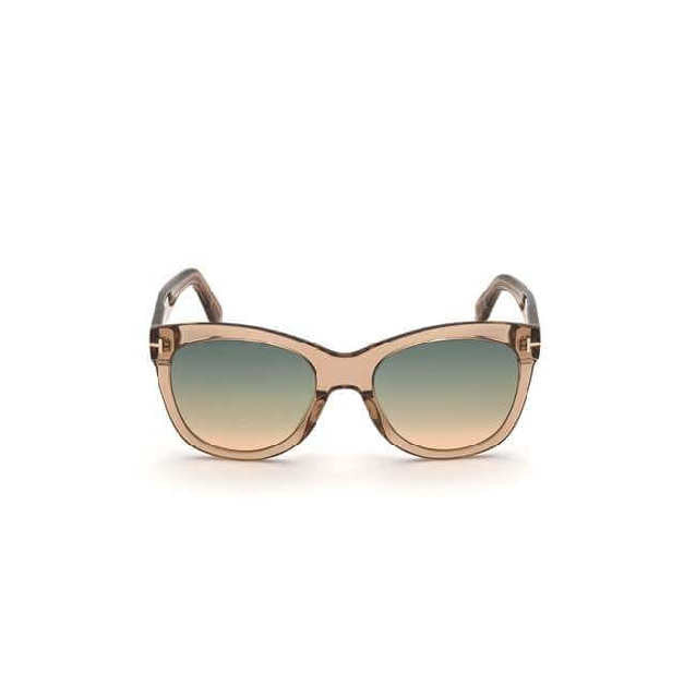 Soft cat-eye acetate style sunglass in a shiny light brown crystal frame with green to brown gradient lenses and a metal 'T' decoration. Front view.